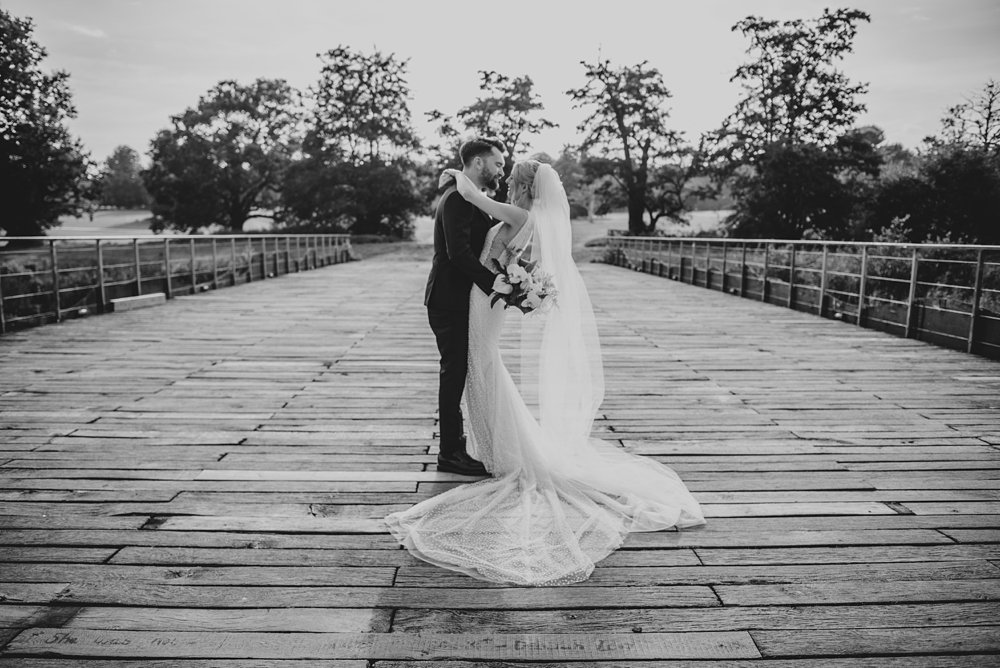 A festival inspired barn venue with lush foliage &amp; greenery leading the styling at Henham Weddings. Bride wears Pronovias Essex documentary wedding photographer.