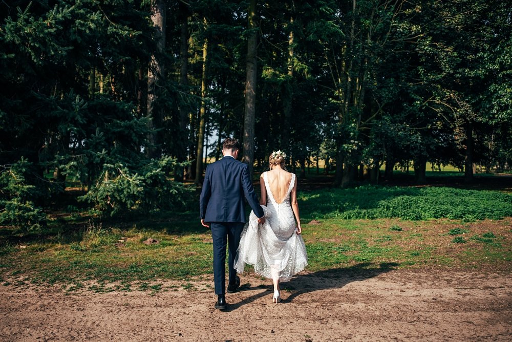 A festival inspired barn venue with lush foliage &amp; greenery leading the styling at Henham Weddings. Essex documentary wedding photographer.