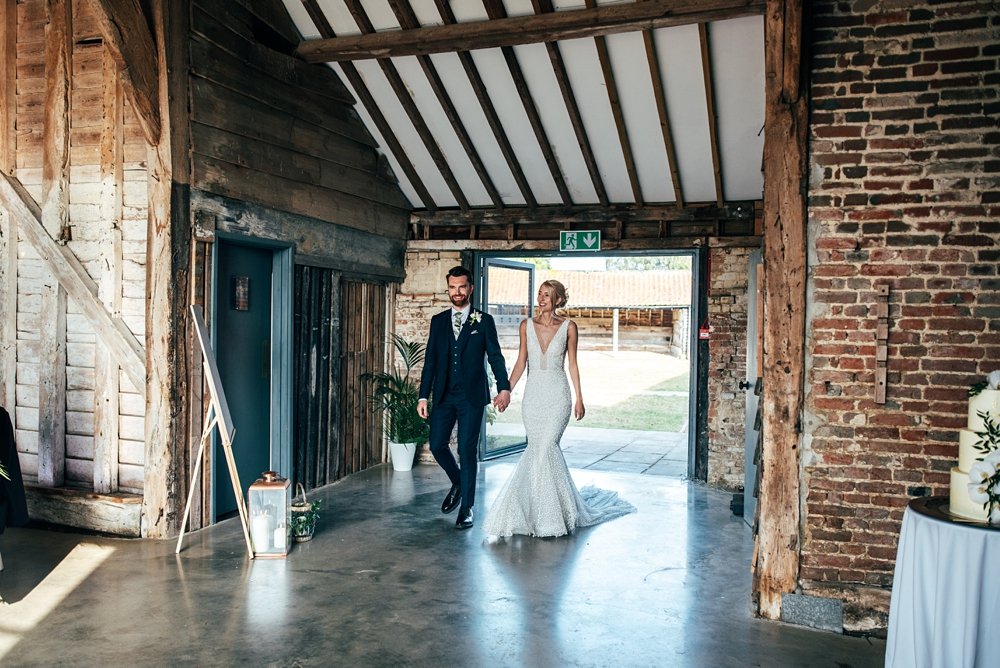 A festival inspired barn venue with lush tropical foliage &amp; greenery leading the styling at Henham Weddings. Essex documentary wedding photographer.