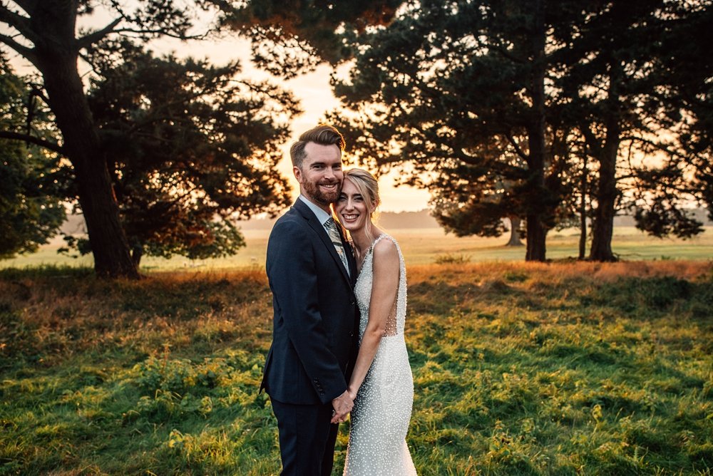 A festival inspired barn venue with lush tropical foliage &amp; greenery leading the styling at Henham Weddings. Essex documentary wedding photographer. Bride wears Pronovias at golden hour
