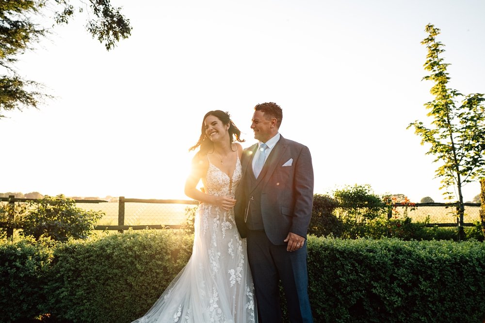 An outdoor, back garden, clear roof marquee wedding with statement Spring flower arch &amp; chandelier Essex documentary wedding photographer