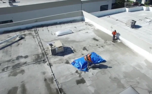 Roofers preparing commercial flat roof before restoration work