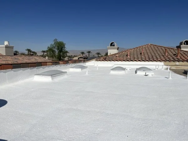 Finished white residential flat roof with multiple skylights