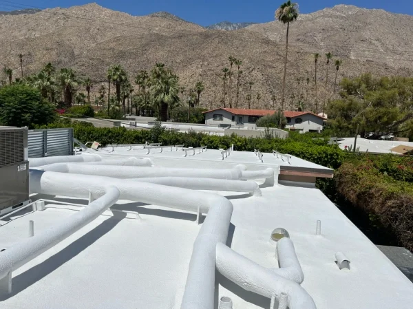 Completed white reflective coating covering residential flat roof system.