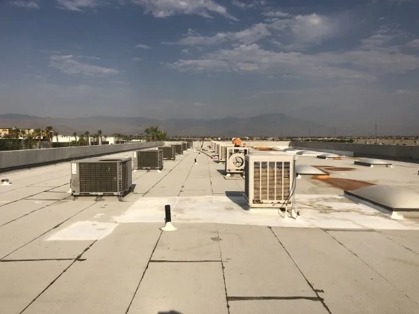 Reflective commercial flat roof with rooftop HVAC equipment installed.