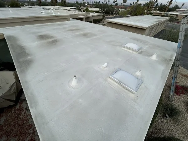 White flat roof with skylights and vent penetrations