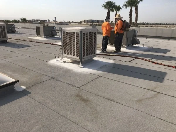 Commercial rooftop HVAC units before reflective roof coating application.
