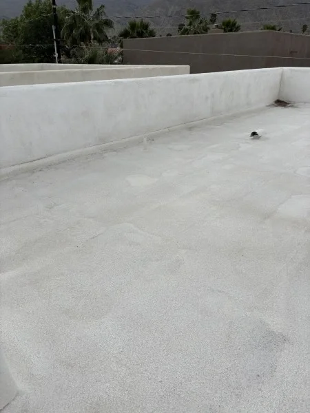 White coated flat roof with parapet walls surrounding