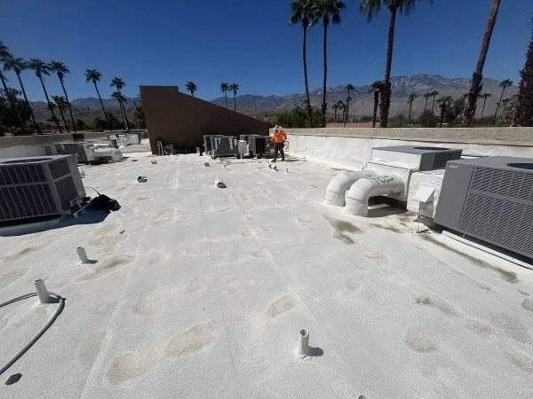 Weathered commercial flat roof surrounding multiple rooftop HVAC units