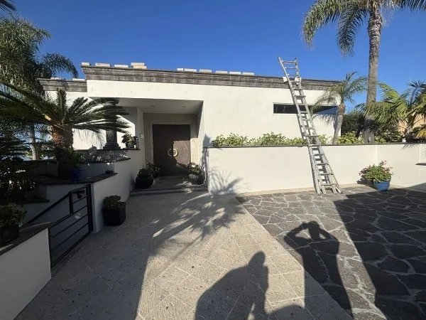 Modern home prepared for flat roof replacement and restoration.