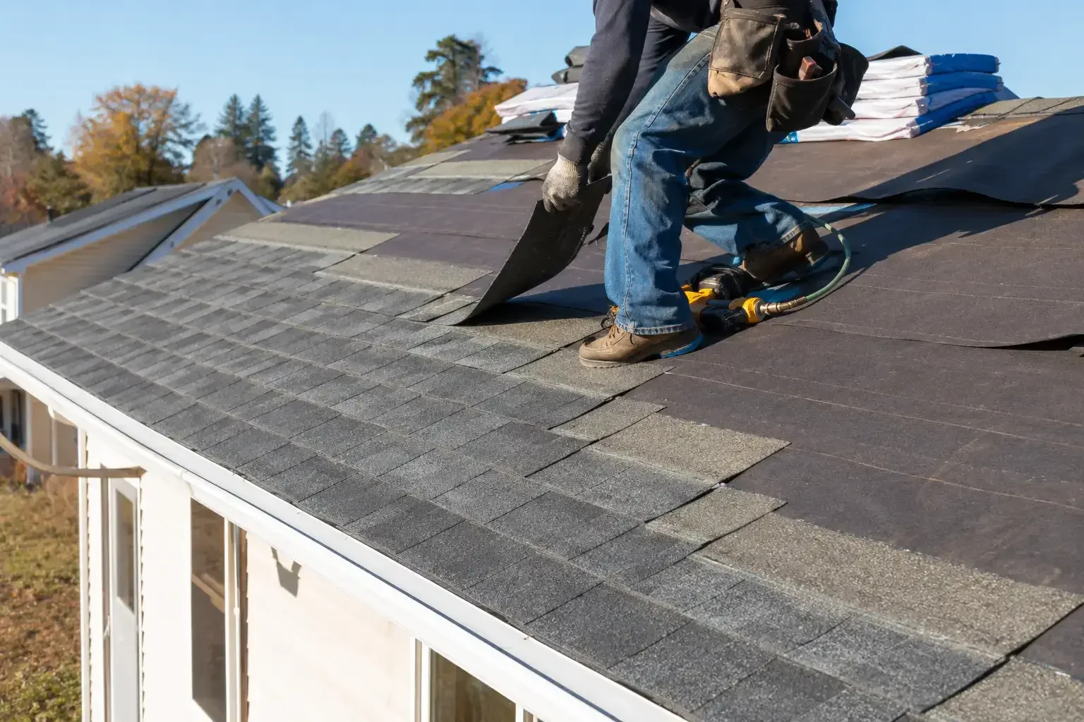 Residential roofer installing asphalt shingles