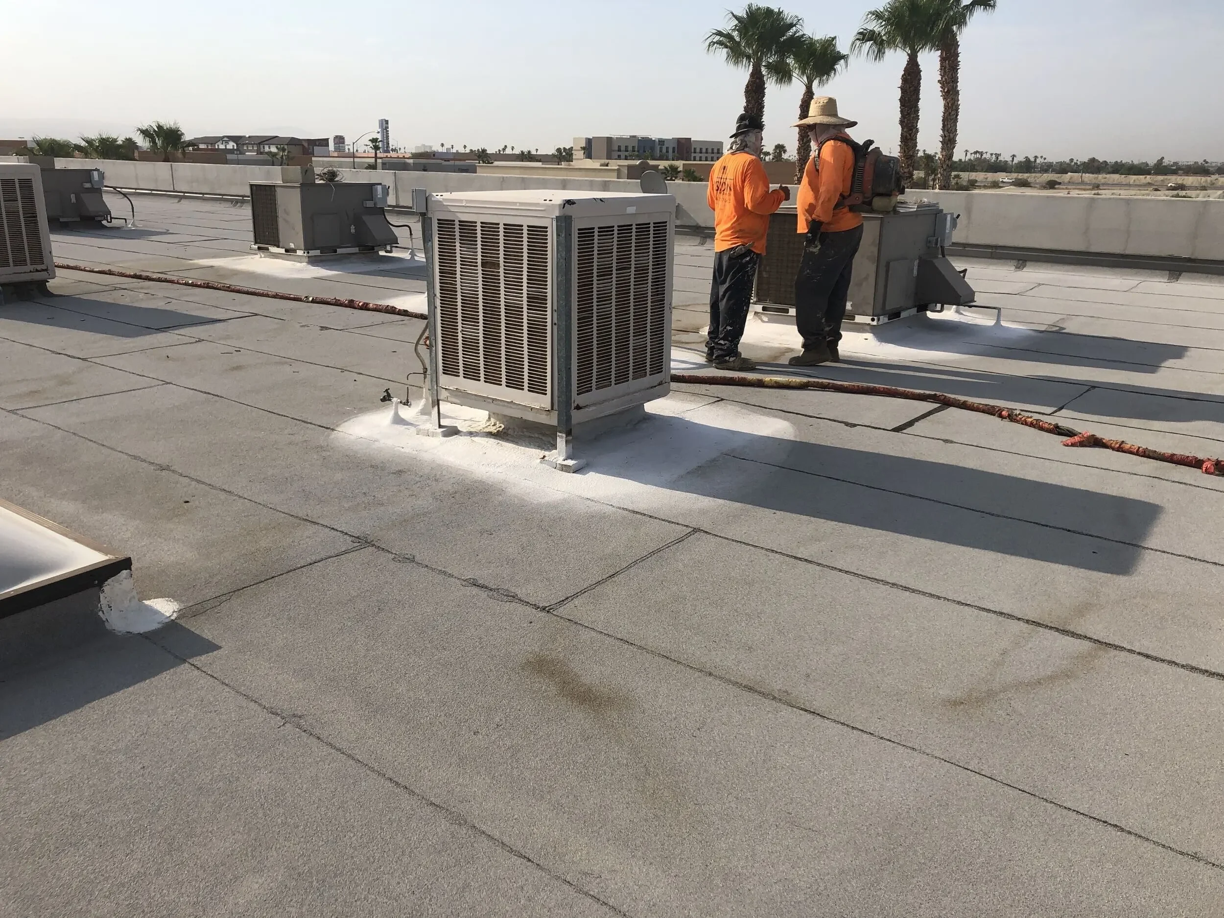 Roofing crew working on a commercial flat roof