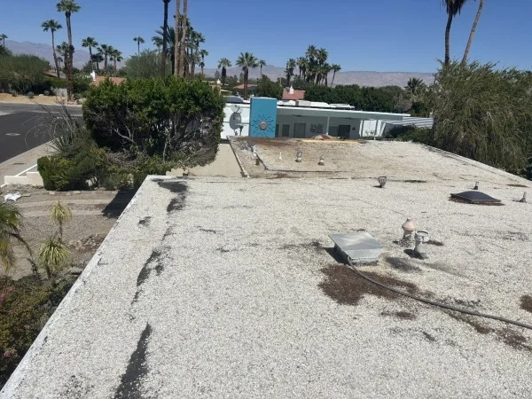 Weathered gravel roof requiring professional restoration and roof coating.