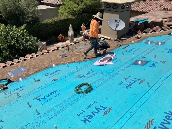 Roofer working across newly installed residential roof underlayment