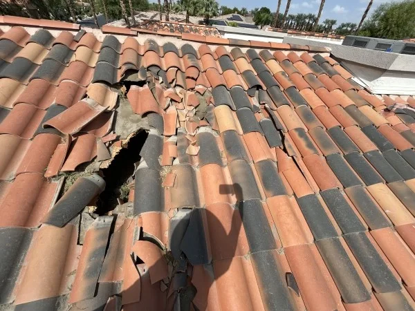 Severely damaged clay tile roof requiring emergency roof replacement.