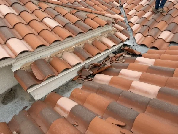 Broken clay roof valley requiring professional roofing restoration services.