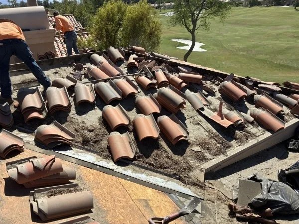 Clay tile roof replacement with removed tiles and exposed underlayment.
