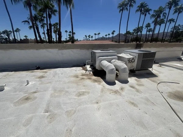 Commercial rooftop HVAC equipment on completed reflective roof coating.