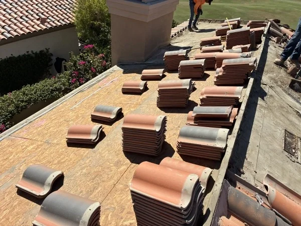 Stacked clay roof tiles prepared for professional roof replacement.