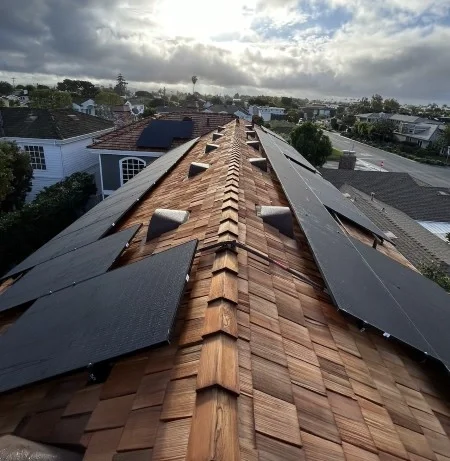 Solar panels installed across premium cedar shake residential roof.