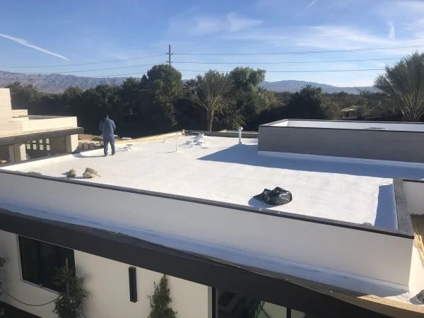 Finished white flat roof coating on modern luxury residence.