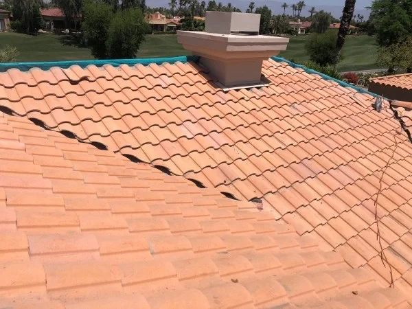 Concrete tile roof prepared for repairs with lifted roof tiles.