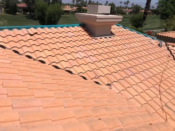 Completed clay tile roof surrounding residential chimney structure