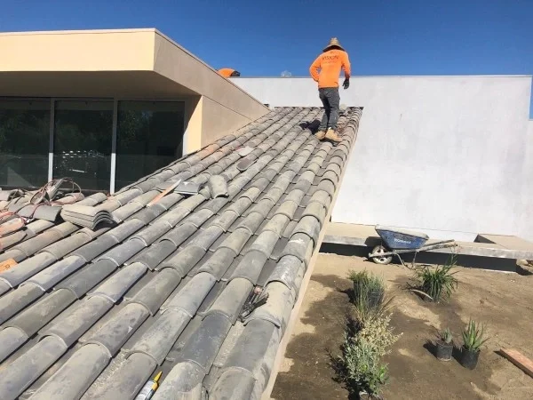 Roofer working on clay tile residential roof installation