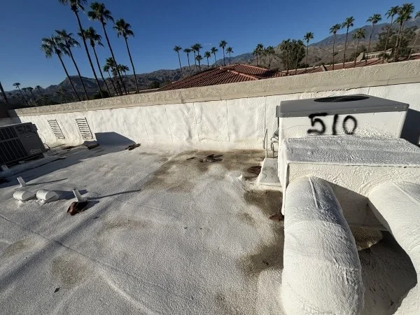 Reflective commercial roof coating surrounding rooftop HVAC equipment installation.