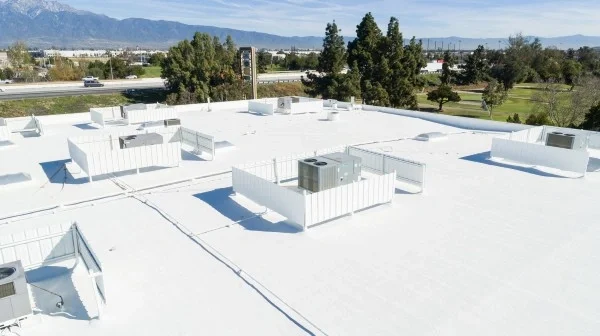 Completed commercial white foam roof with protected HVAC equipment.