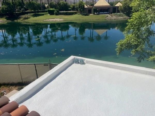 Finished white flat roof overlooking landscaped residential lake