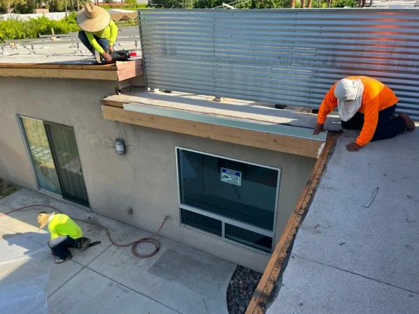 Roofing crew repairing edges of residential flat roof