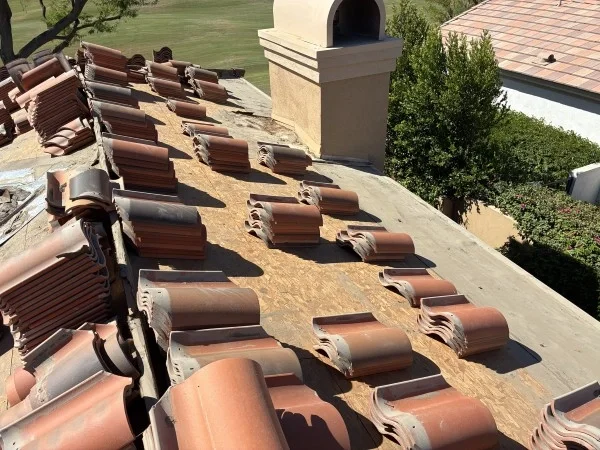 Roof decking exposed beneath removed concrete roof tiles carefully.