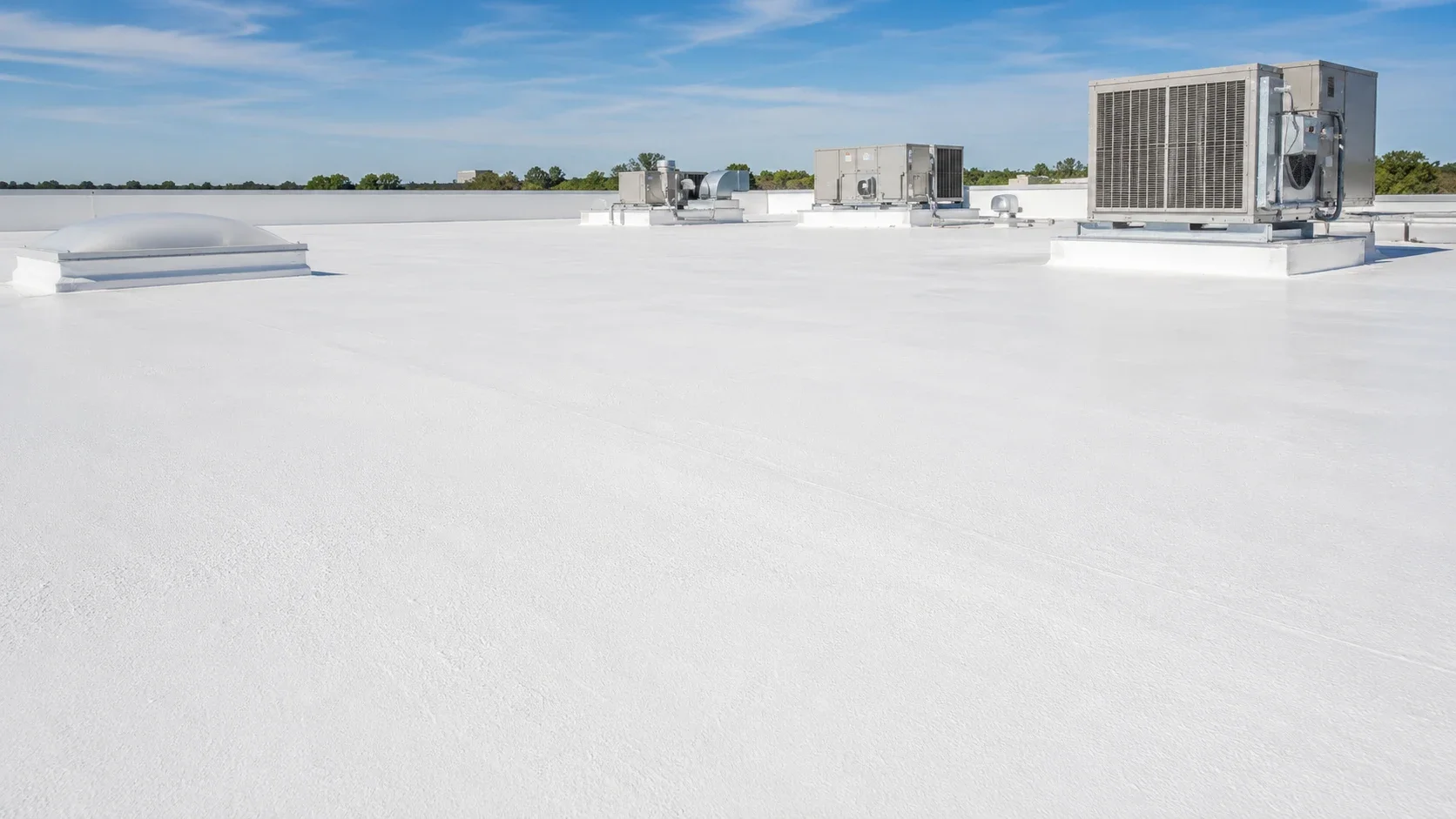 Commercial flat roof with white silicone-coated spray foam on an Irvine building