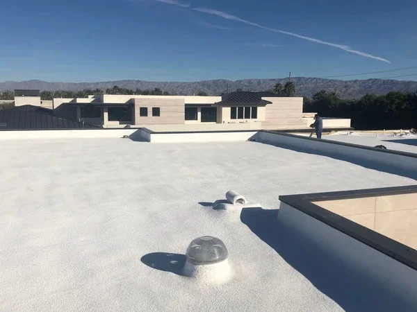 Contractor spraying a no-seam polyurethane foam roof