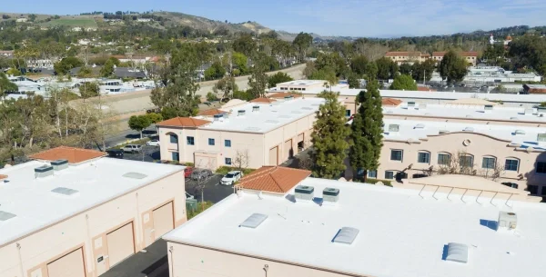 Aerial view of commercial buildings with white reflective roofs