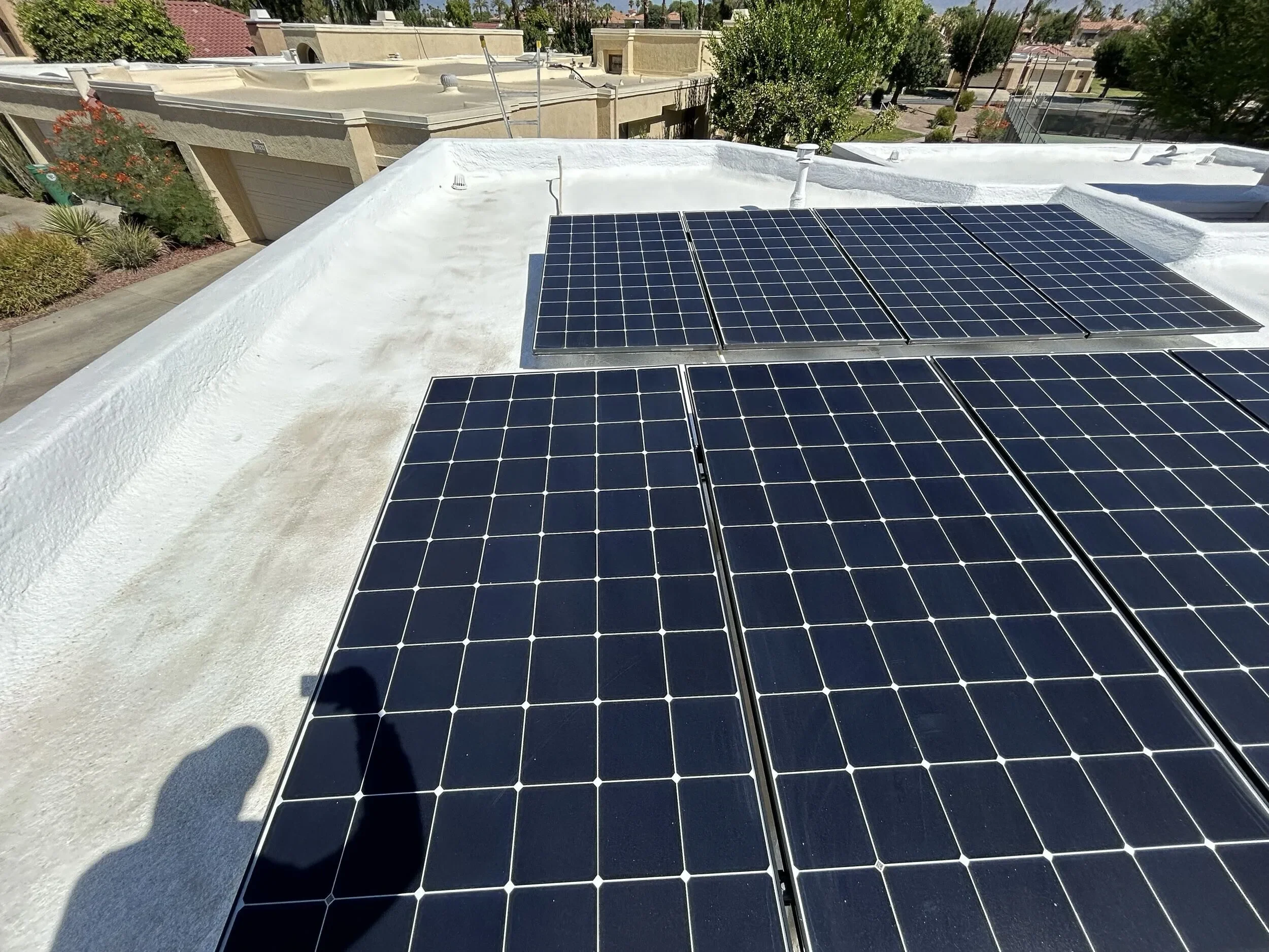 Solar panels installed on a white residential flat roof