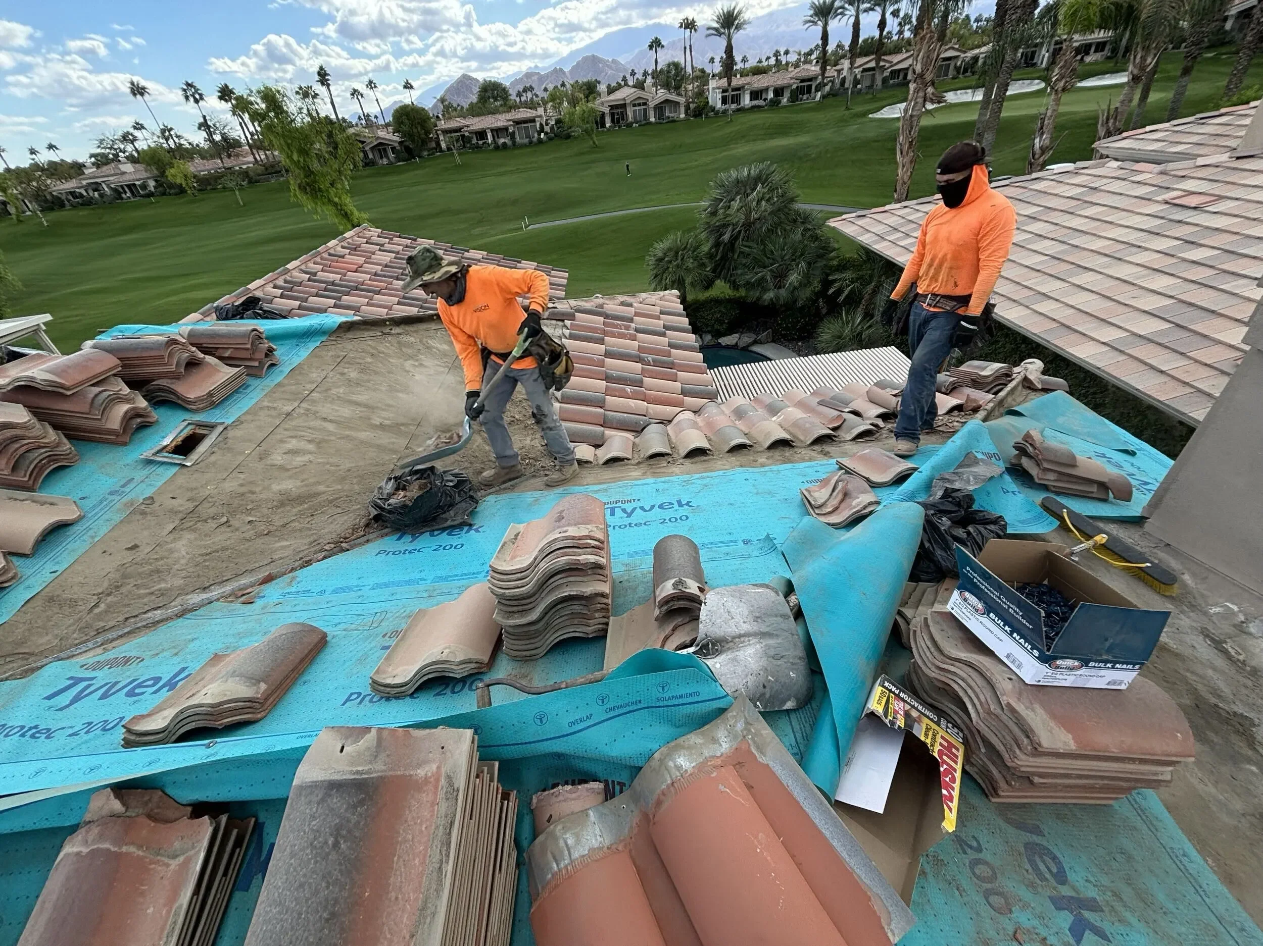 Roofing crew working on a residential tile roof
