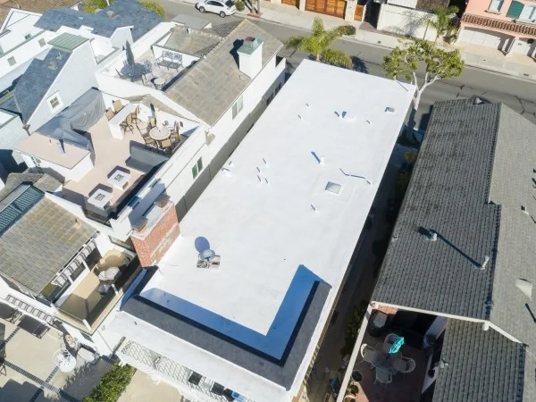 Aerial view of completed white flat roof installation