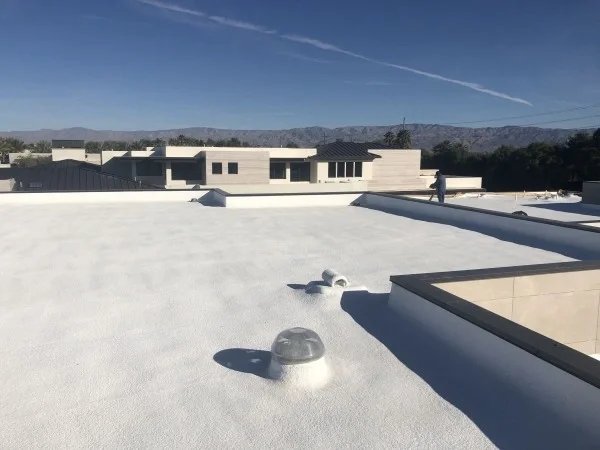 Newly coated white flat roof with durable waterproof membrane system.