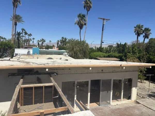 Flat roof renovation with exposed framing and roofing improvements.