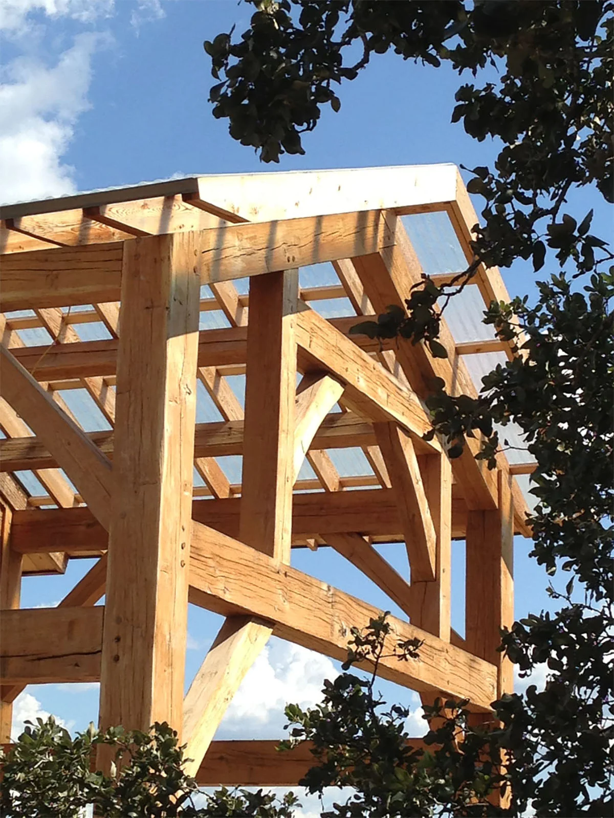 Timber frame at covered porch of sitting room barn with translucent roofing - DH