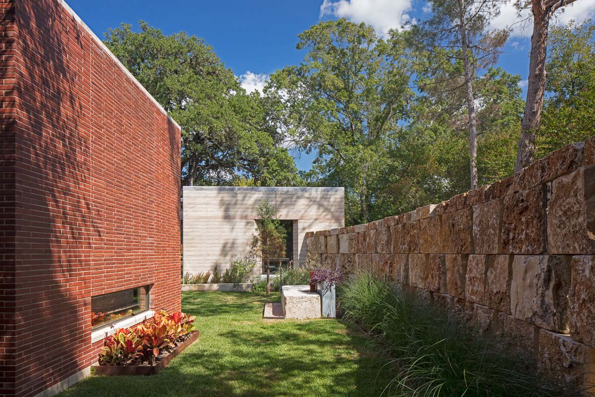 South courtyard - dining pavilion at left, stack stone wall at driveway and studio beyond