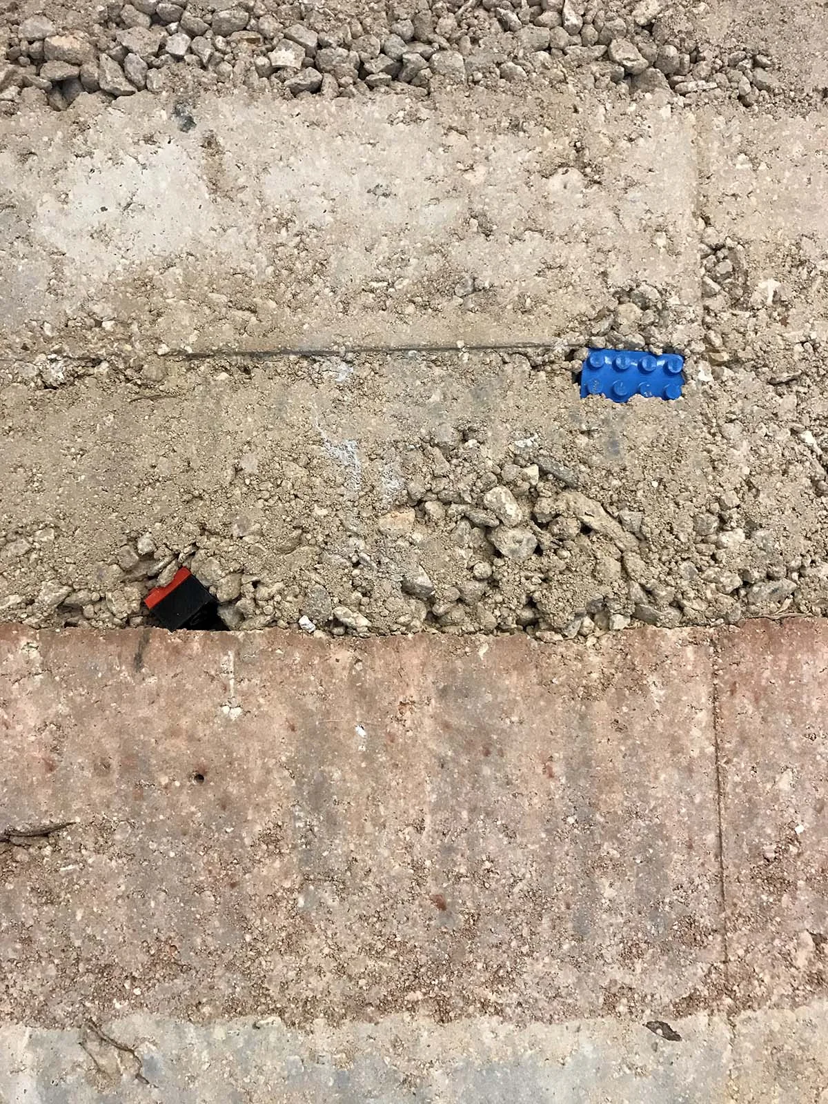 Designer's childhood LEGOs placed in rammed earth wall
