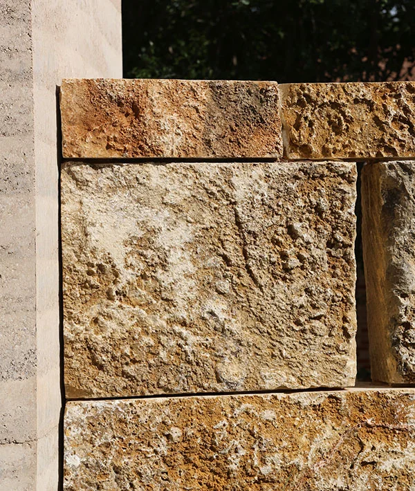 Intersection of rammed earth wall and stacked block site wall