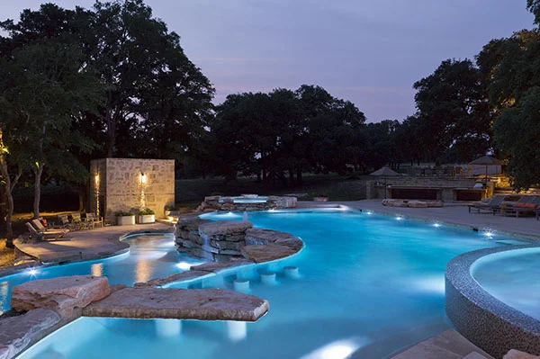 View of upper and lower pool areas and pump house beyond at dusk - PB