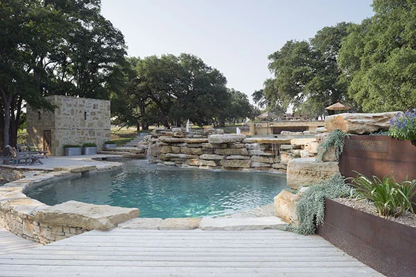 View of lower swimming hole pool, waterfall and pump house beyond - PB