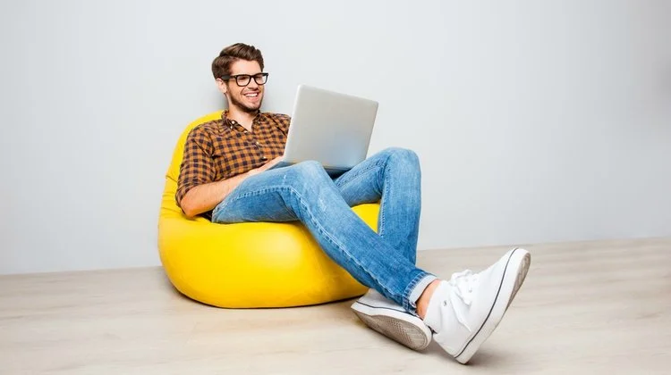 happy-man-using-laptop-on-yellow-beanbag.jpg