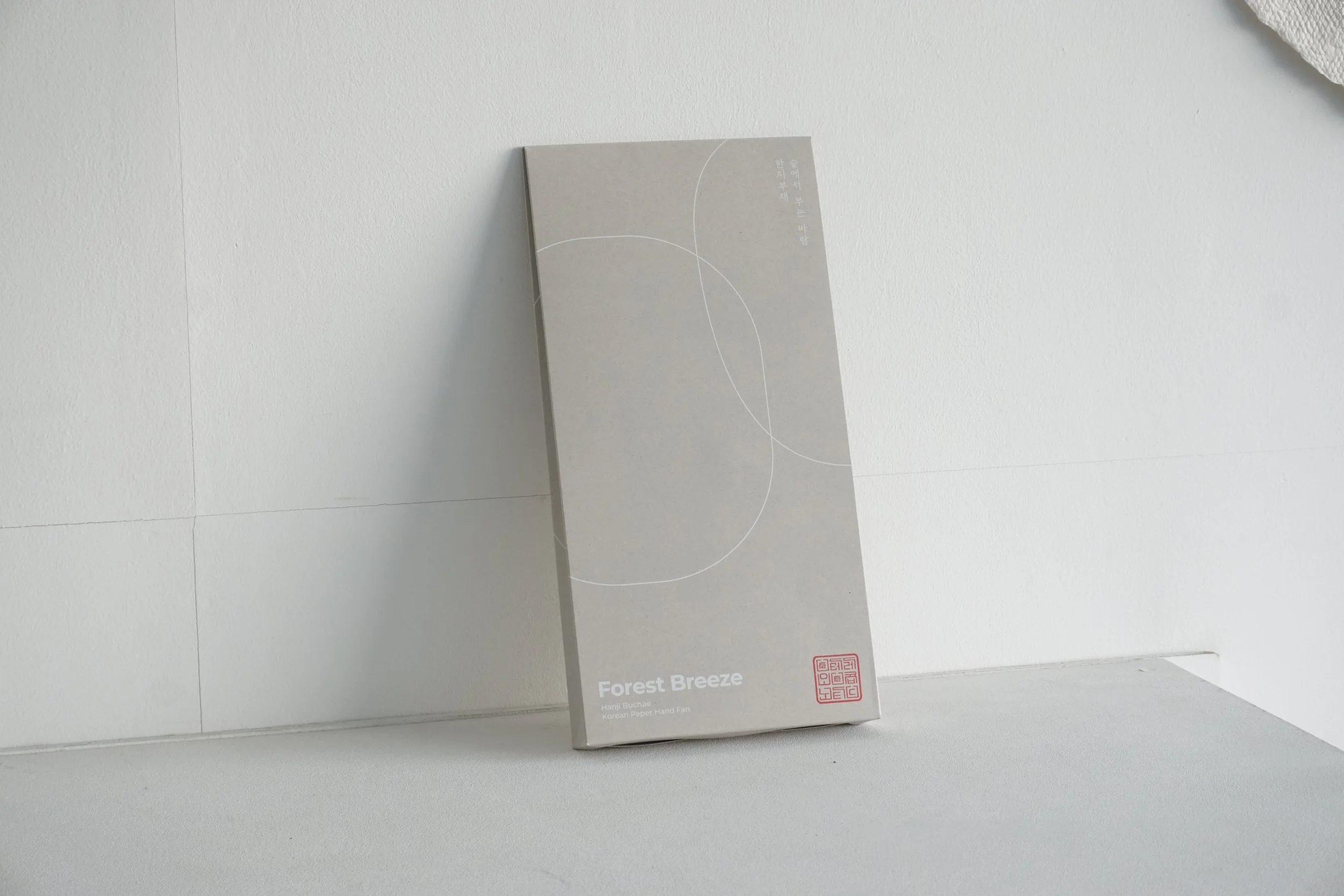 gray flat square box that the fans are packaged in and laid against the wall