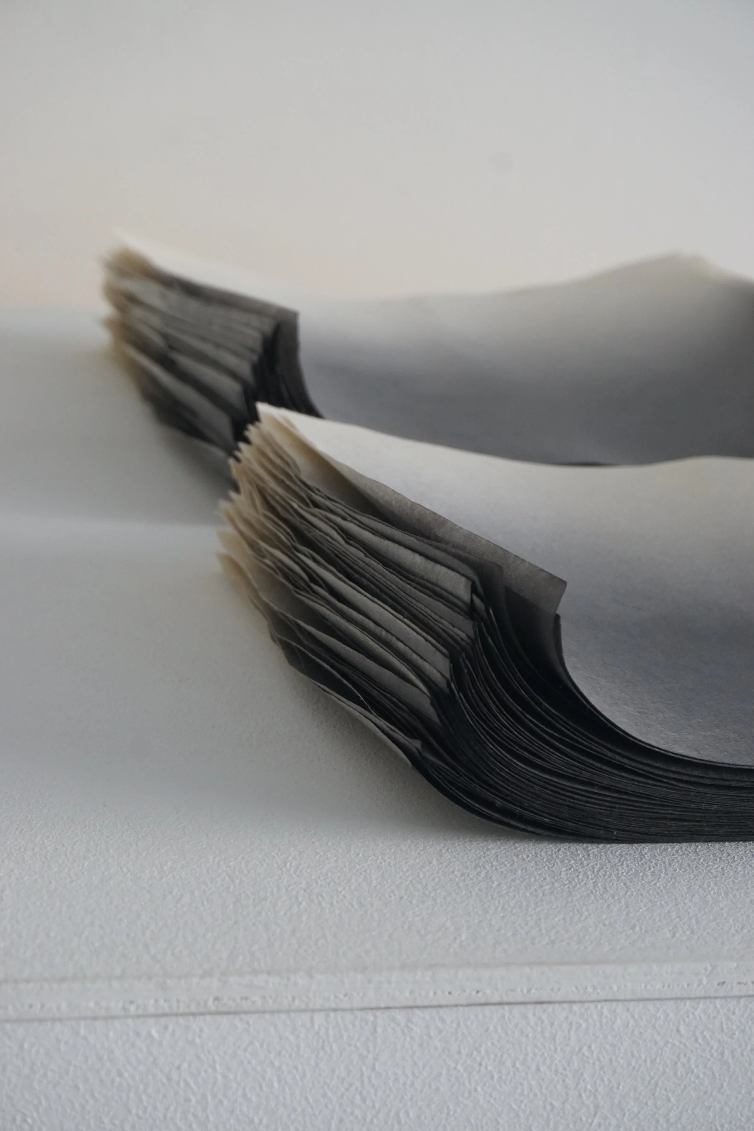 stacks of hand-dyed hand-made paper in a black and white gradient